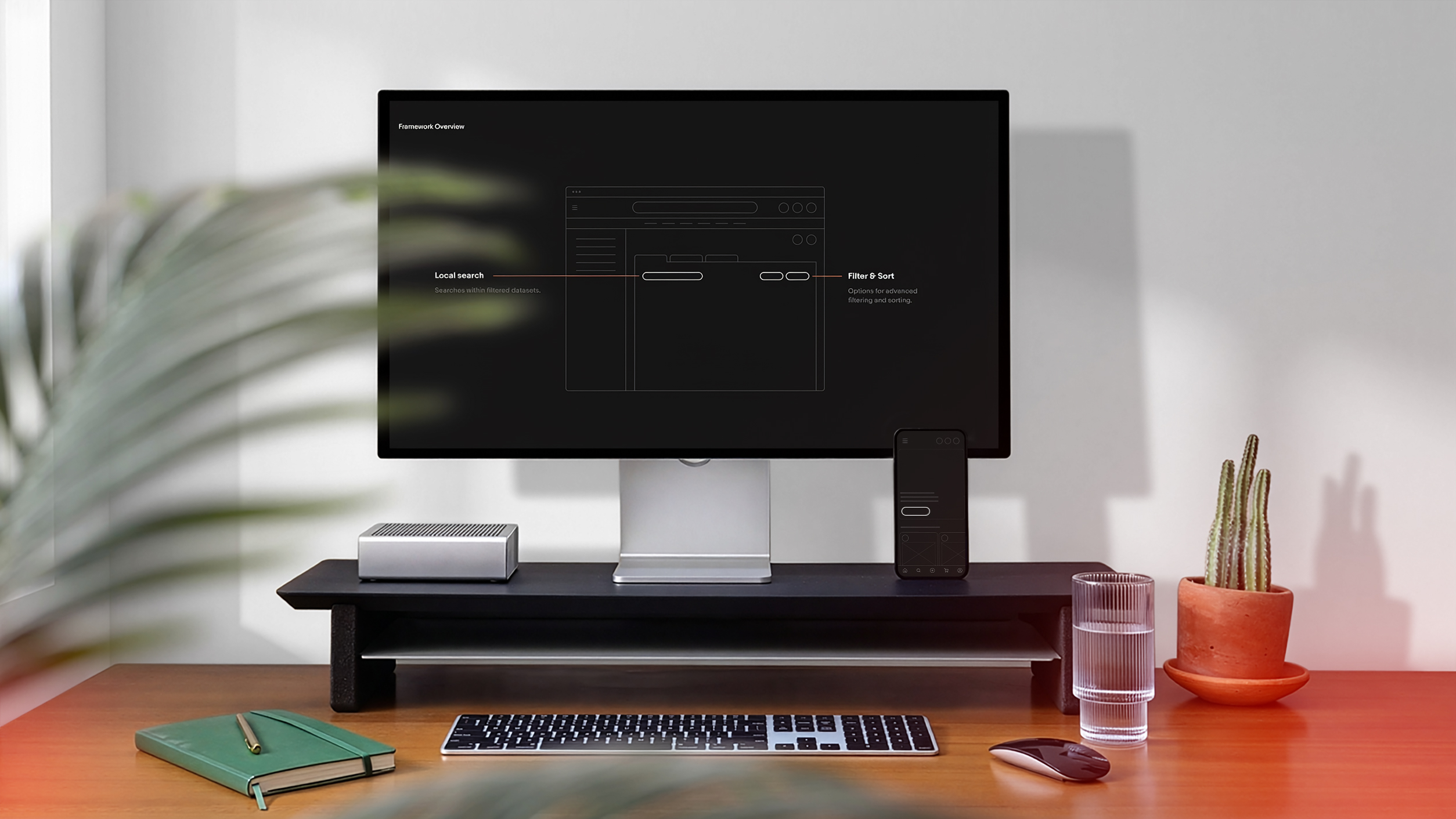 A desk with a monitor showing a product interface wireframe